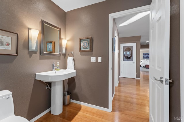 bathroom with hardwood / wood-style floors and toilet