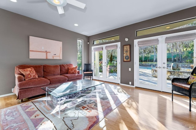 living room with ceiling fan, light wood-type flooring, and french doors