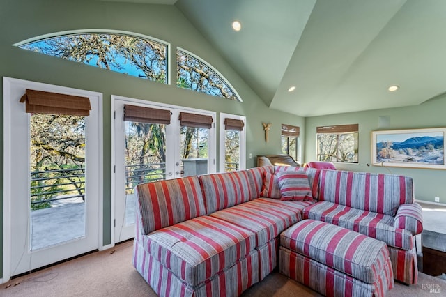 carpeted living room featuring high vaulted ceiling and french doors