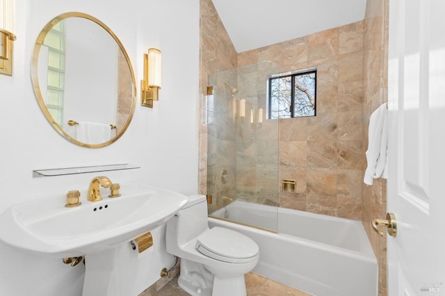 bathroom featuring toilet and combined bath / shower with glass door