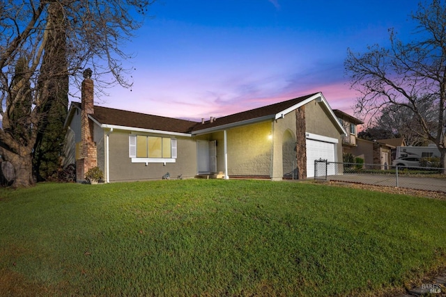 ranch-style house with a garage and a lawn