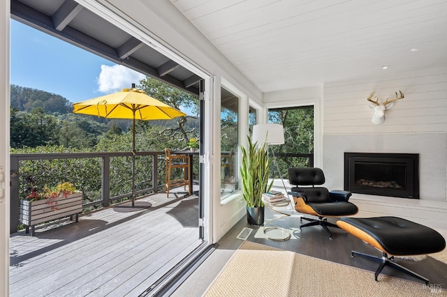 sunroom / solarium with a healthy amount of sunlight and a fireplace