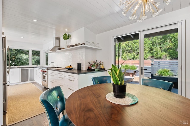 dining room with a notable chandelier, wood ceiling, and light hardwood / wood-style flooring