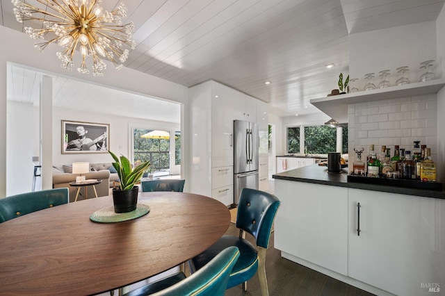 dining space with dark hardwood / wood-style flooring, wooden ceiling, and a chandelier