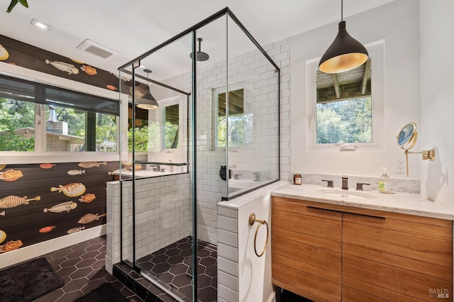 bathroom featuring vanity, an enclosed shower, tile patterned flooring, and a wealth of natural light