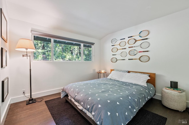 bedroom featuring wood-type flooring and vaulted ceiling