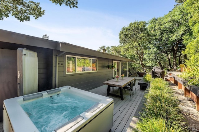 wooden terrace featuring an outdoor hot tub and a grill