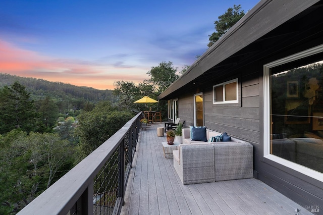 deck at dusk featuring outdoor lounge area