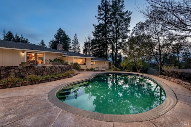 pool at dusk with a patio