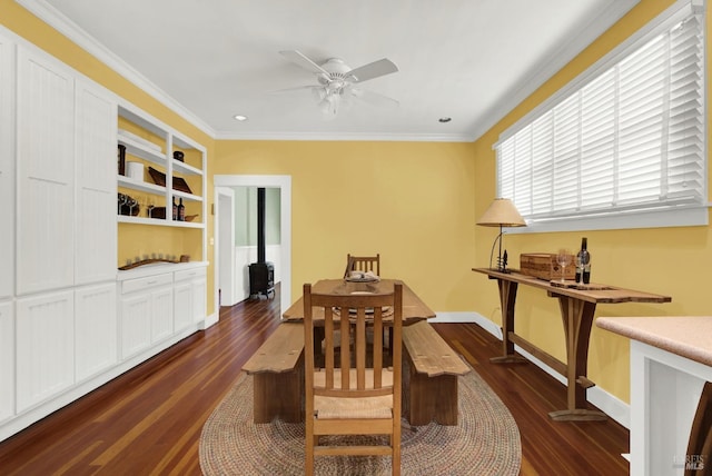 dining space featuring crown molding, a wood stove, dark wood-type flooring, and ceiling fan