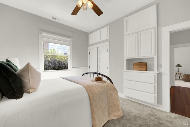 bedroom with light carpet, ceiling fan, and a closet