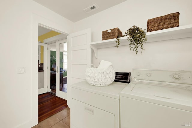 clothes washing area featuring separate washer and dryer and light tile patterned flooring