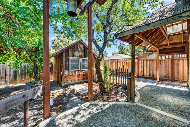 wooden deck with an outdoor structure and a patio