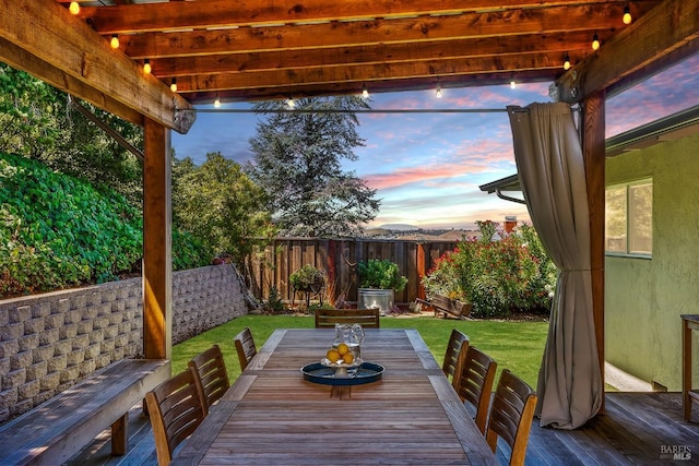 patio terrace at dusk with a yard and a pergola