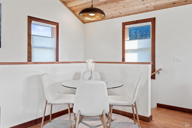 dining area featuring lofted ceiling, light wood-type flooring, and wooden ceiling