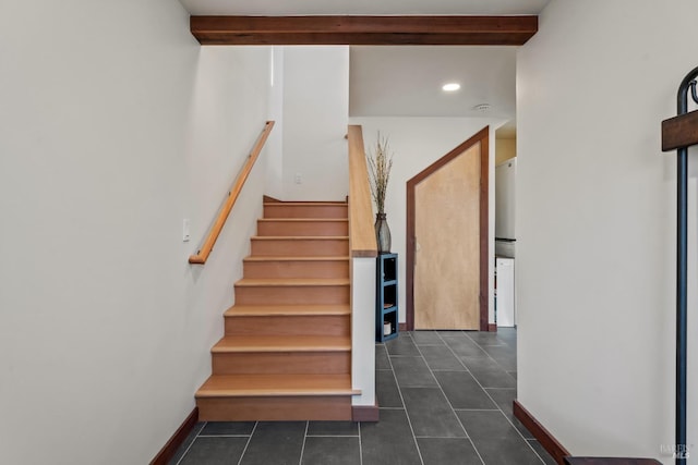 stairway featuring tile patterned floors and beamed ceiling