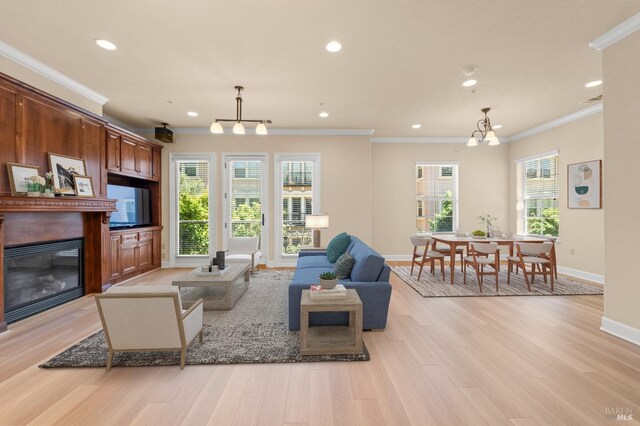 1120 Sonata Dr, Vallejo, CA 94591 - living area with a chandelier, a glass covered fireplace, light wood finished floors, recessed lighting, and ornamental molding