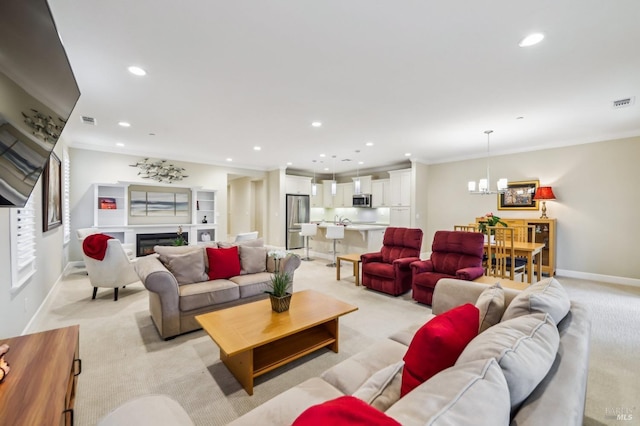 living room featuring crown molding, light colored carpet, and a notable chandelier