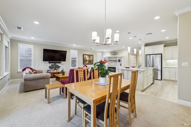 carpeted dining room with sink, a notable chandelier, and ornamental molding