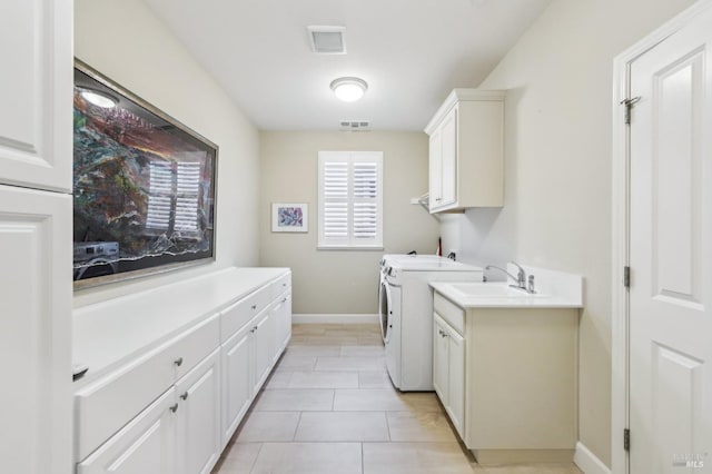 laundry area featuring cabinets, light tile patterned flooring, sink, and independent washer and dryer