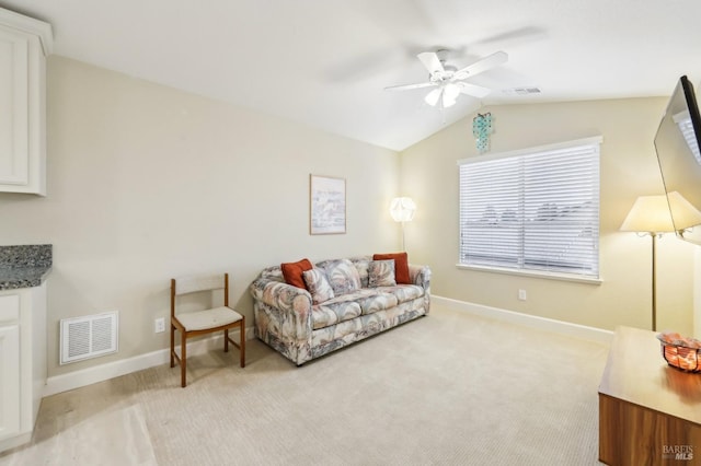 living room with ceiling fan, lofted ceiling, and light carpet