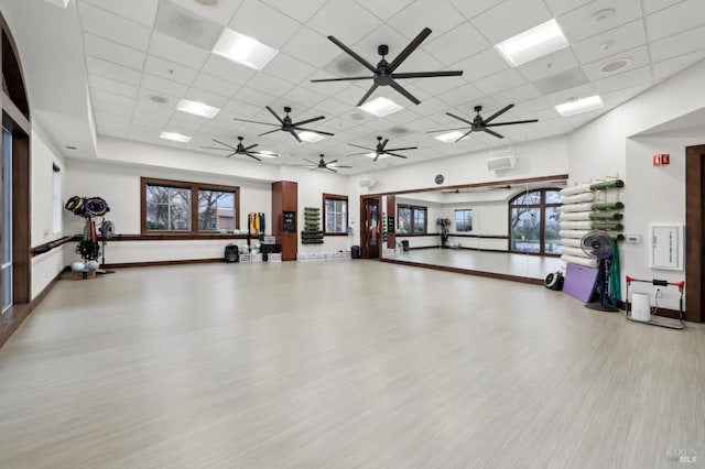 gym with a drop ceiling, a towering ceiling, and wood-type flooring