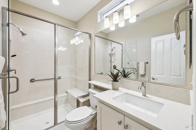 bathroom with vanity, a shower with shower door, and toilet