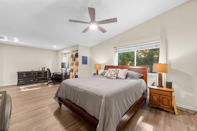 bedroom featuring hardwood / wood-style flooring, vaulted ceiling, and ceiling fan