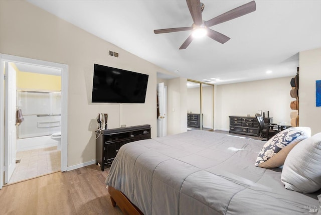 bedroom with ensuite bathroom, hardwood / wood-style floors, lofted ceiling, ceiling fan, and a closet