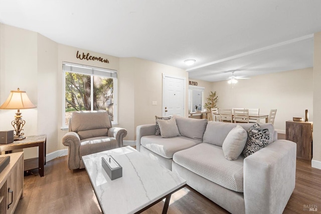 living room with dark wood-type flooring and ceiling fan