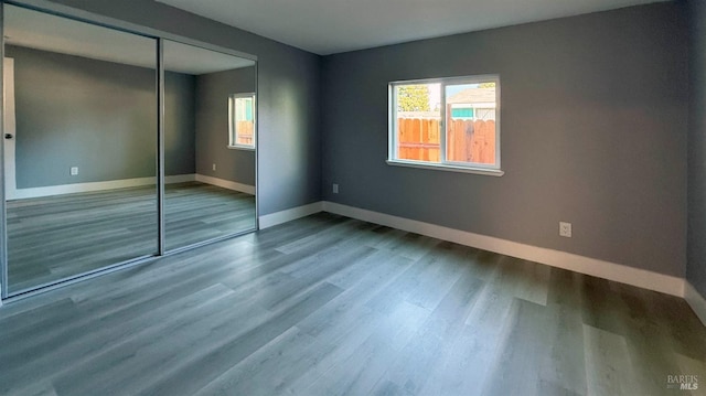 unfurnished bedroom with wood-type flooring and a closet