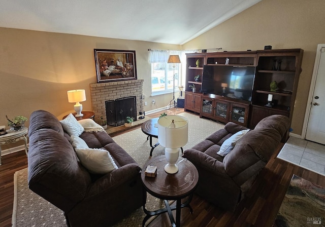 living room featuring lofted ceiling, hardwood / wood-style floors, and a brick fireplace