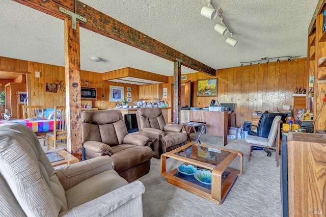 carpeted living room with a textured ceiling, beamed ceiling, and wooden walls