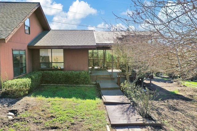 exterior space with a front yard and roof with shingles