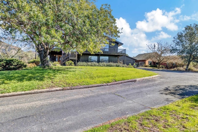 view of front of property featuring a front lawn and stairs