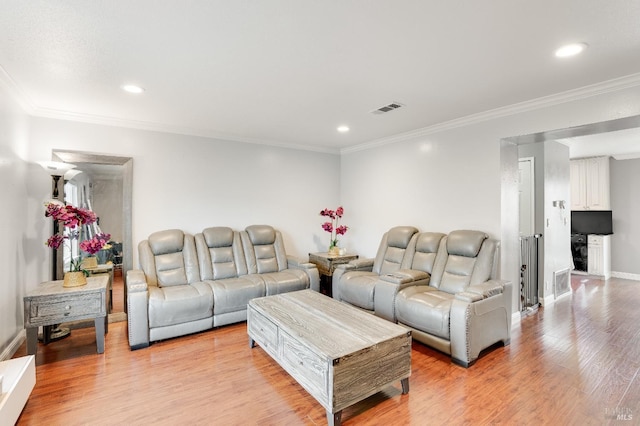 living room with ornamental molding and light hardwood / wood-style floors