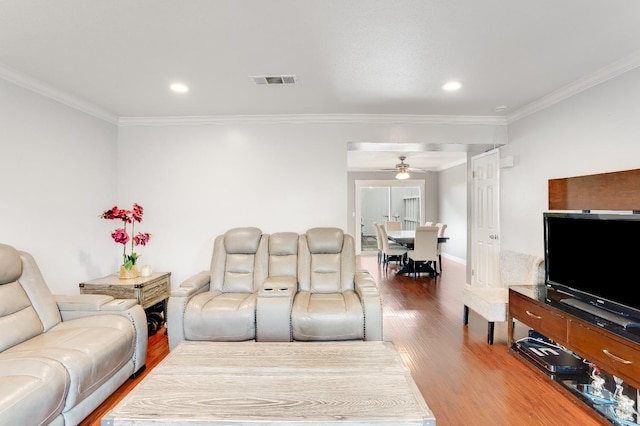 living room with hardwood / wood-style flooring, ceiling fan, and crown molding