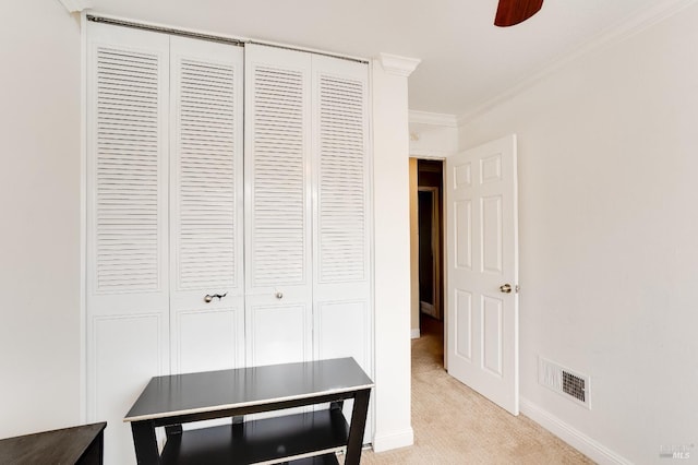 interior space featuring crown molding, light colored carpet, and ceiling fan