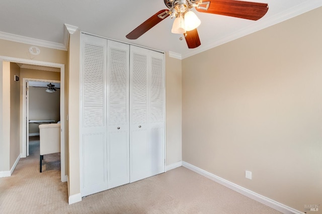 unfurnished bedroom featuring ornamental molding, light colored carpet, and a closet