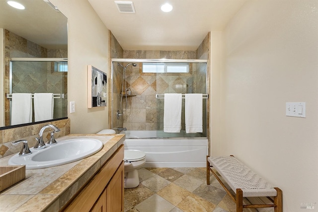 full bathroom with toilet, vanity, and shower / bath combination with glass door