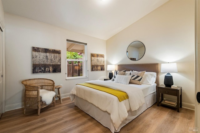 bedroom featuring hardwood / wood-style flooring and lofted ceiling