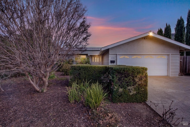 ranch-style house featuring a garage and solar panels