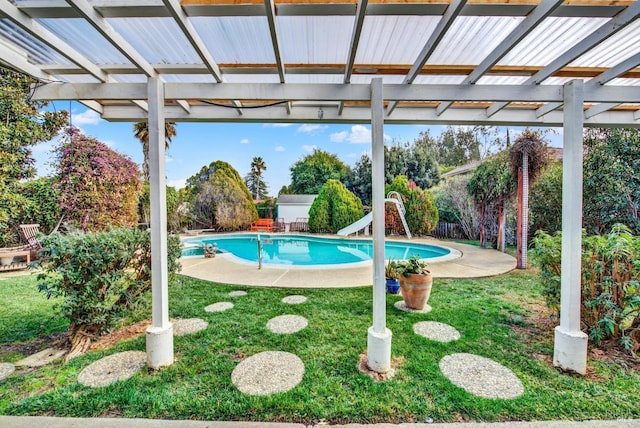 view of swimming pool featuring a water slide, a lawn, and a pergola