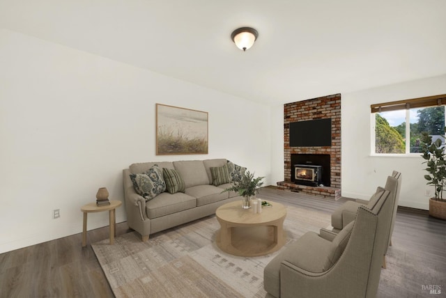 living room featuring hardwood / wood-style flooring and a brick fireplace