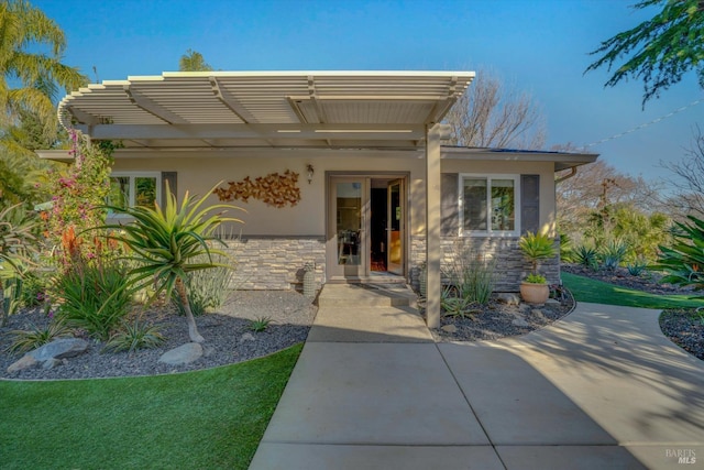 property entrance with a pergola