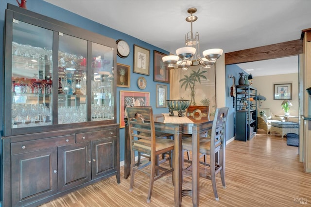 dining space featuring light hardwood / wood-style flooring and a chandelier