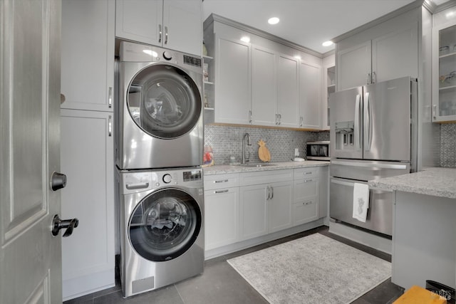 laundry area featuring sink and stacked washer / dryer