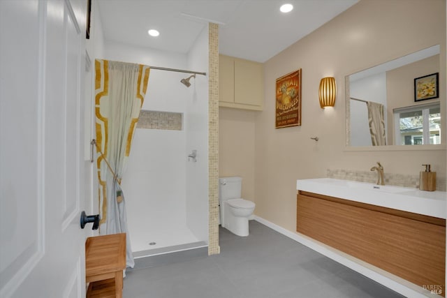 bathroom with vanity, a tile shower, and toilet