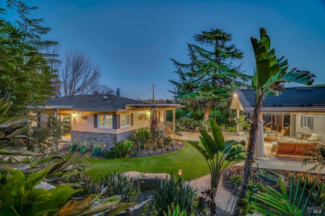 rear view of property featuring a patio, outdoor lounge area, and a yard