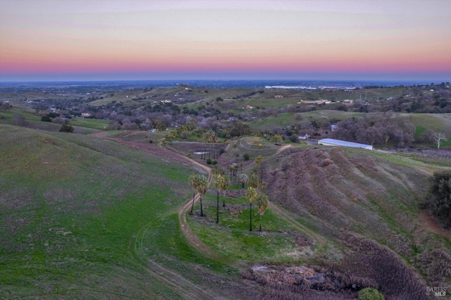 aerial view at dusk featuring a rural view